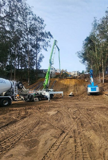 Photo shows machinery drilling holes in slope