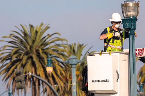 Power lineman installs streetlights.