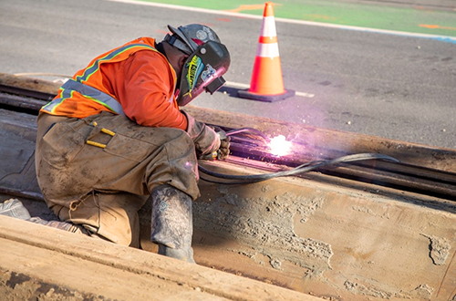 Crews welding sheet piles adjacent to traffic lanes along the Embarcadero