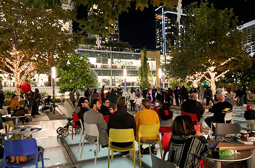 people sitting at tables in a outdoor plaza