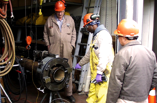 Stationary Engineers, Anthony LaMell, John Staples and John Martin cut a pipe.