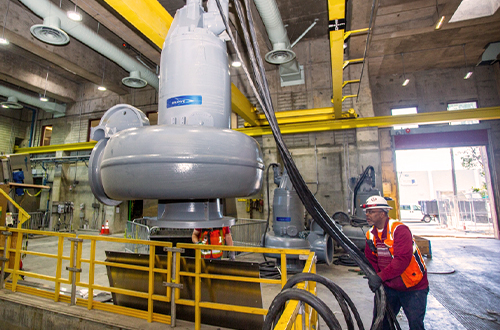 Crew member hoisting large hoses