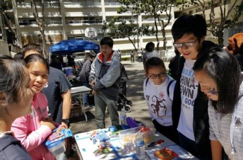 Students looking at art materials on a table