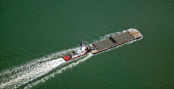 tug boat pushing a modern barge