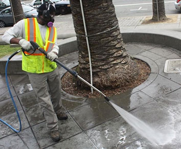 Trabajador de la ciudad lavando acera