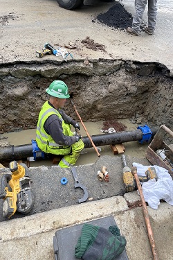 Crews connect a new section of pipe to the main.