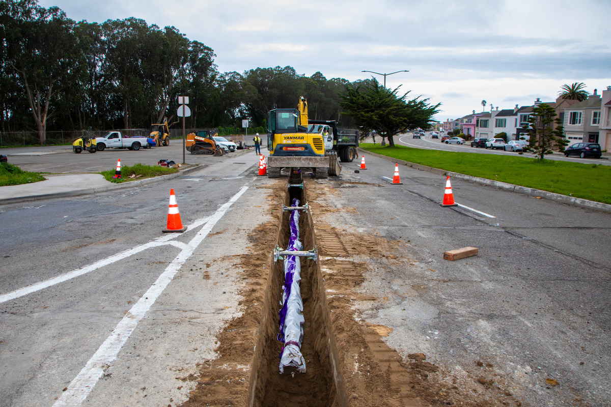 laying recycled water pipe into street trench