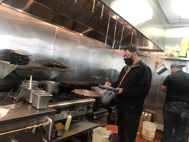 fats, oils and grease control inspector doing commercial kitchen inspection