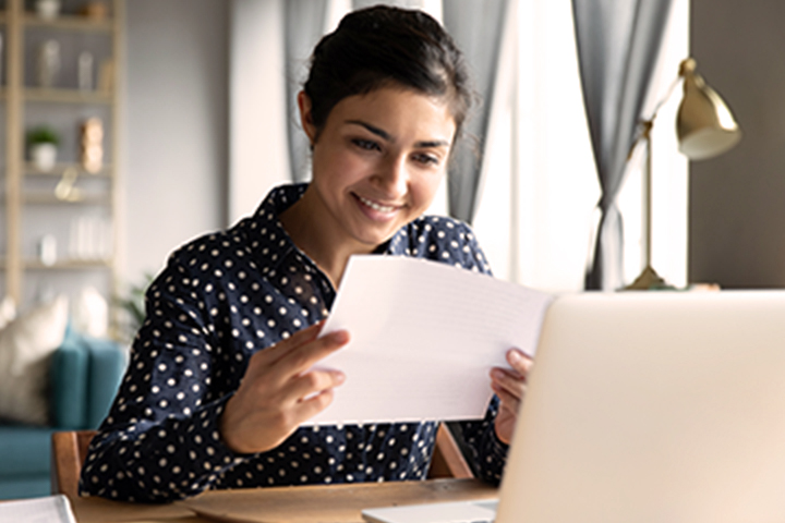 woman reading a document and smiling