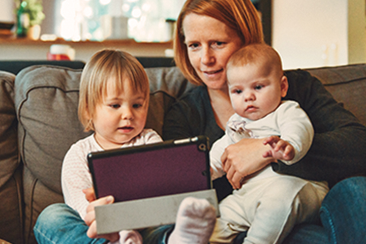 Madre y dos hijos mirando dispositivo tablet