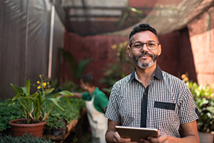 Dueño de la empresa de pie en su tienda de jardinería