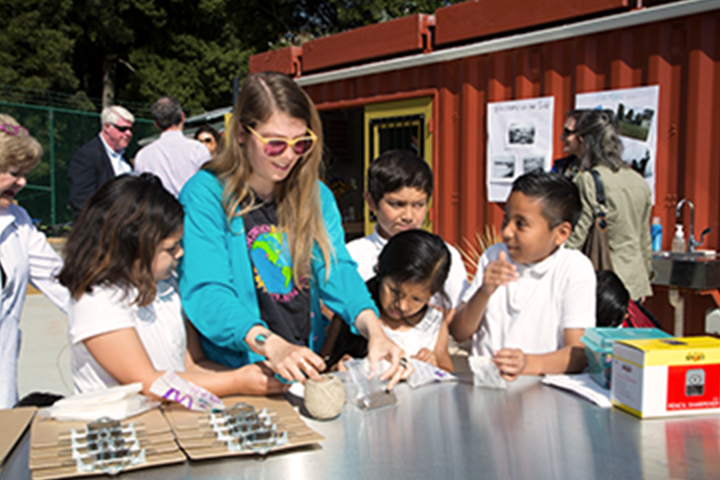 an instructor working with 4 young students