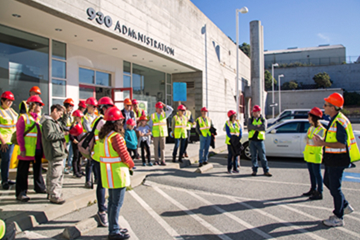 a group in safety vests listening to the tour guide