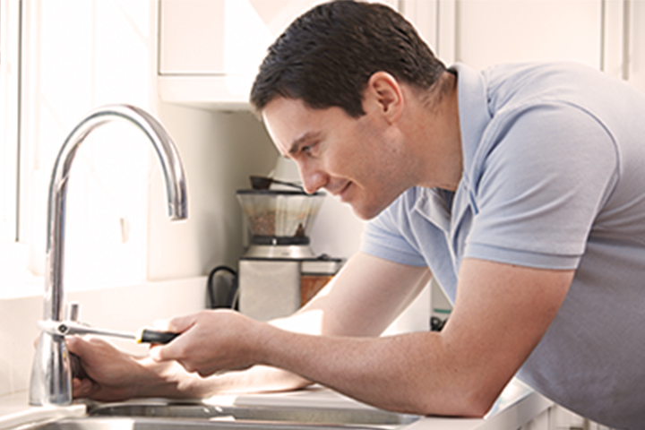 Man washing his hands in the kitchen.