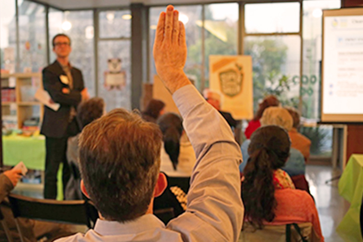 meeting attendees raising hands to ask a question