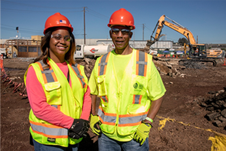 dos trabajadores de la construcción de pie hombro con hombro