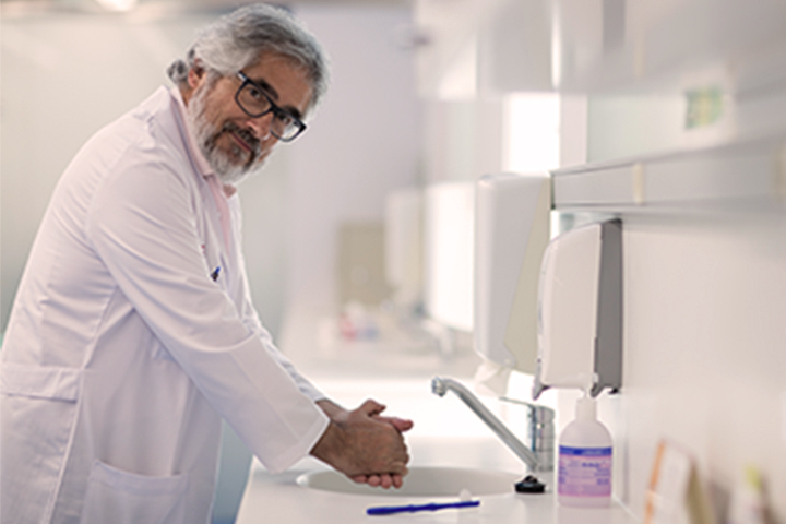 man in lab coat washing hands