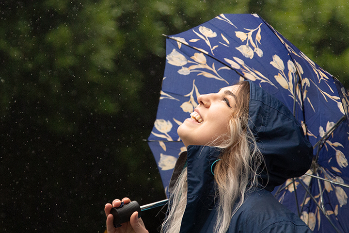 woman with umbrella looking up to the sky