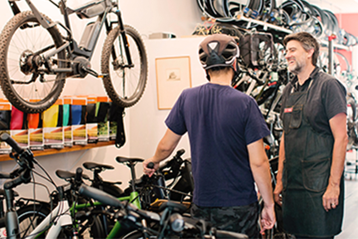 dos hombres hablando dentro de una tienda de bicicletas