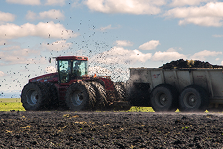 tractor esparcir fertilizante sobre un campo