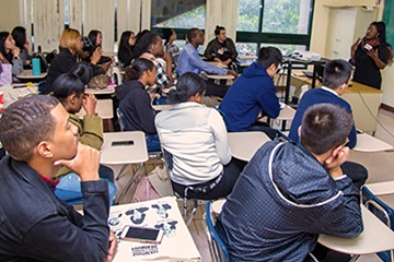 students listening to speaker in front of the class