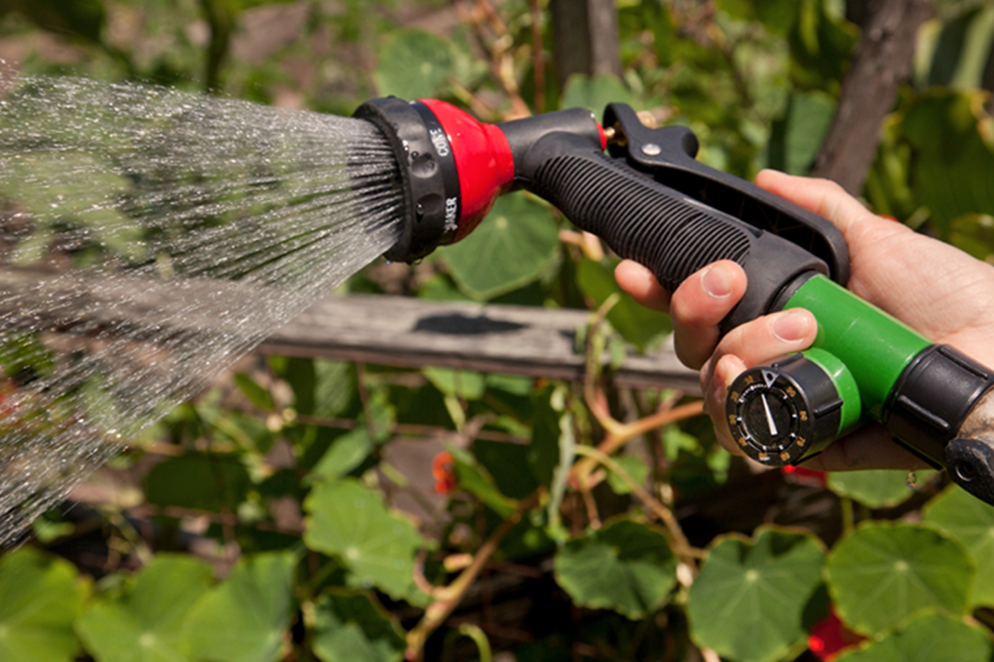 mano sujetando la boquilla de pulverización de jardín