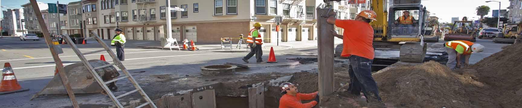 Cuadrillas en zanjas, reparando líneas de alcantarillado.