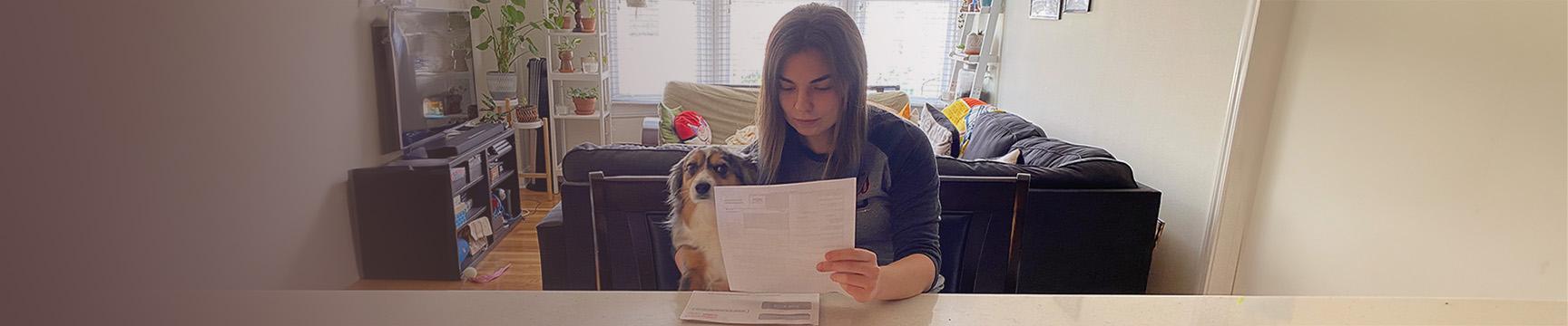 Women with a dog reading her bill.