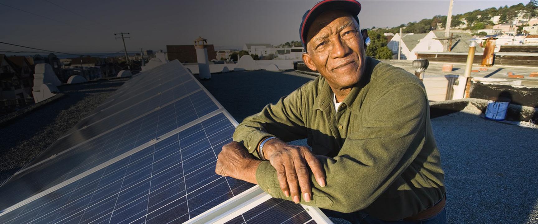 Hombre en el techo apoyado en paneles solares