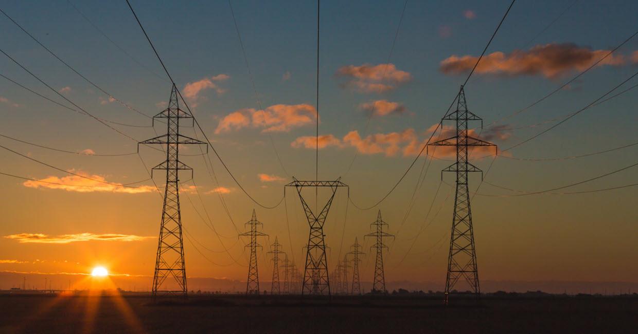 Rows of power lines with the sunset in the background.