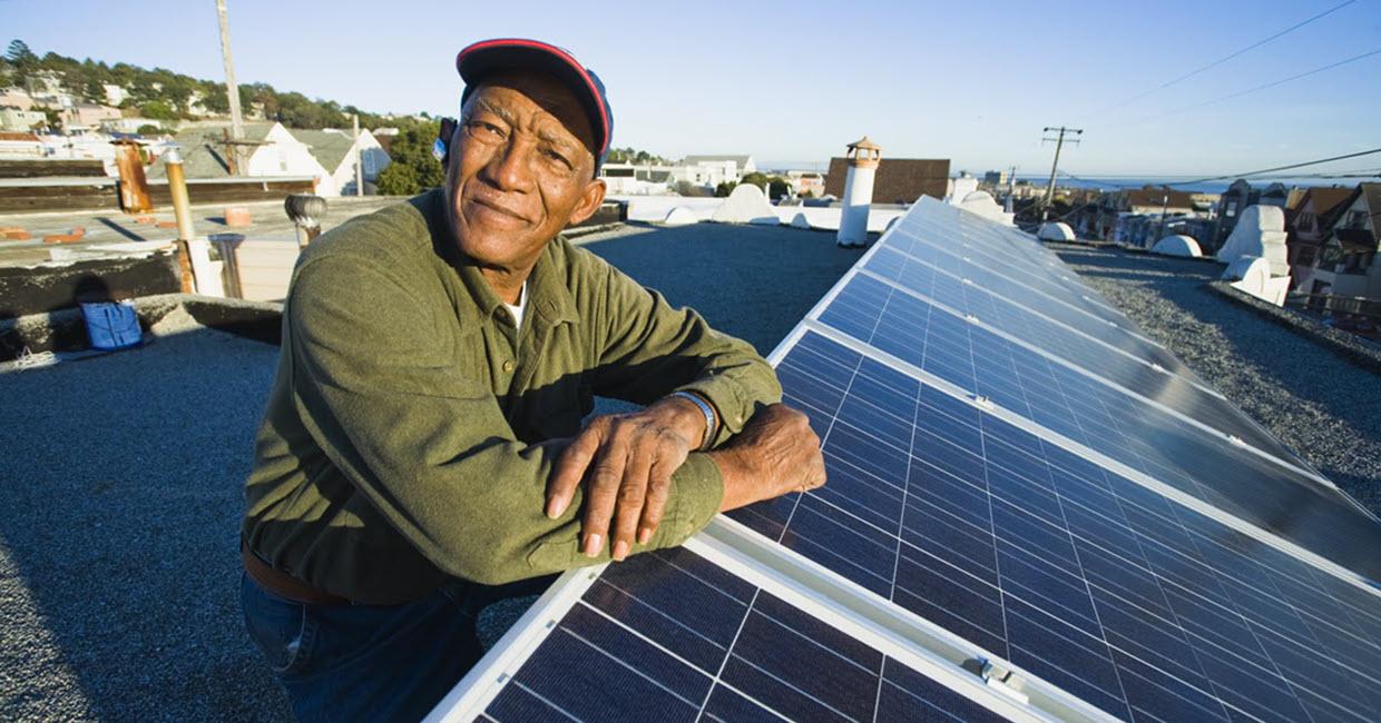 A man stands by a solar array.