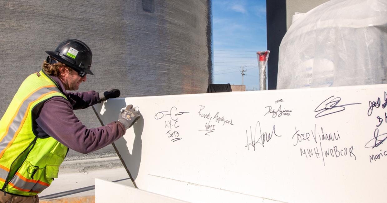 Will Crow, an inspector with the SFPUC’s Construction Management Team, signs the steel beam that will be the highest beam placed on the Biosolids Digesters Project (BDFP).