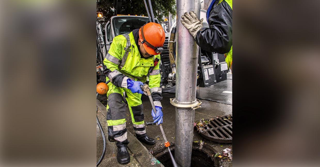 SFPUC worker cleaning a storm drain.