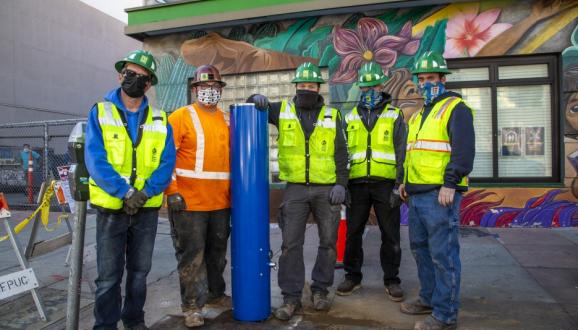 installation crew standing with new tap station