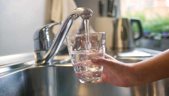 Pouring tap water from the faucet